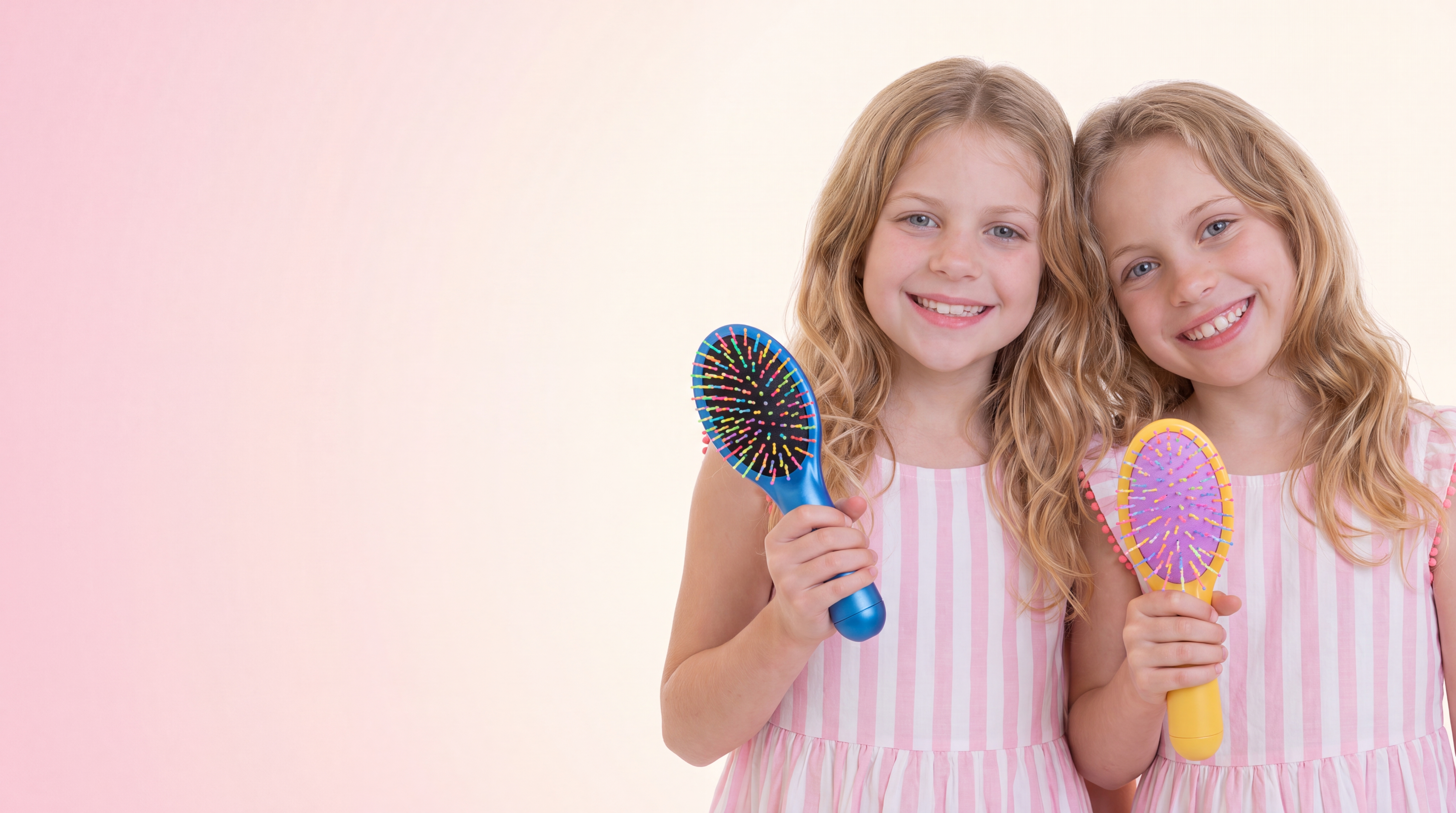 Chloe and Autumn holding GLAM rainbow brushes